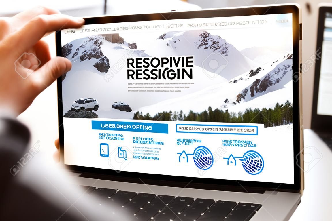 User opening laptop showing responsive web design website