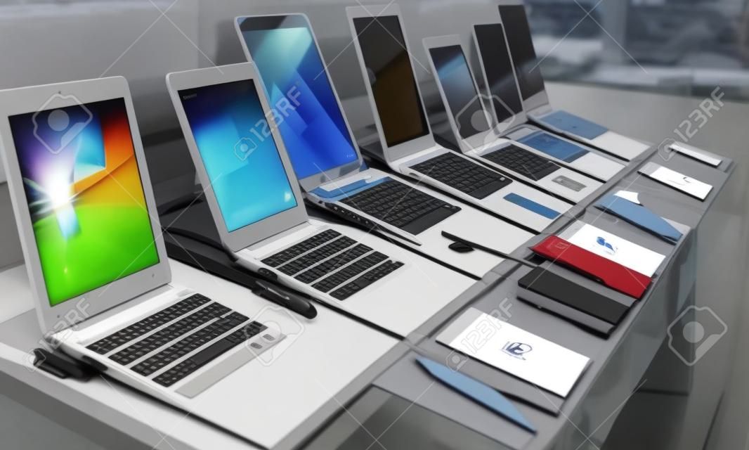 Différents types d'ordinateurs portables sont présentés à la vente dans la vitrine.
