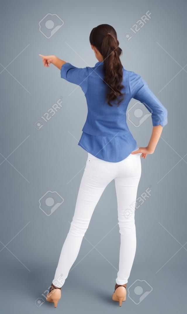  woman pointing. Back view . beautiful brunette girl in shirt gesture.  Rear view people collection.  backside view of person.  Isolated over white background.