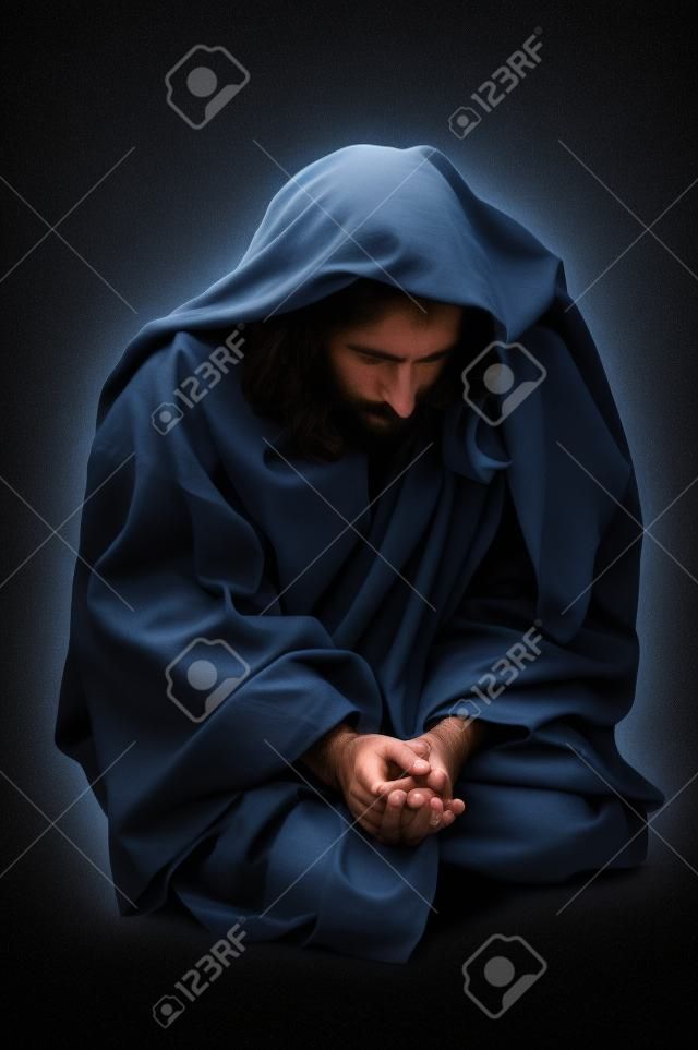 Jesús orando de rodillas sobre un fondo negro