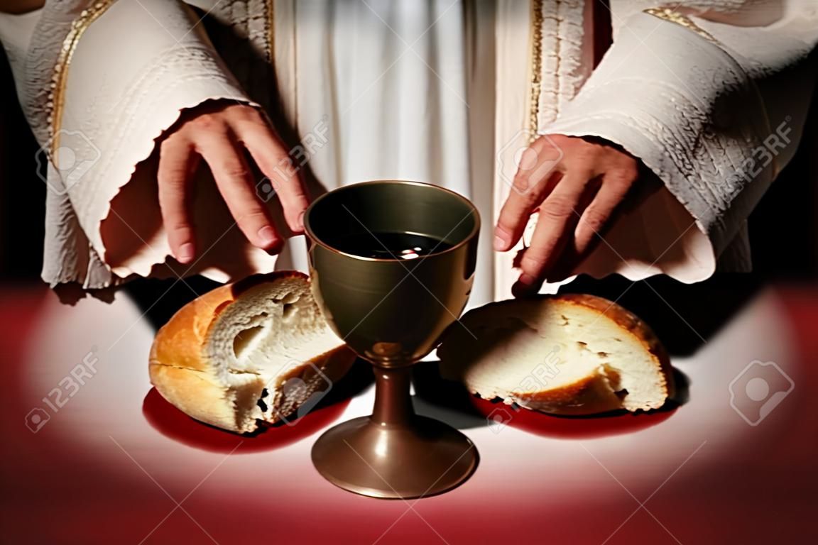 The hands of Jesus offering the Communion wine and bread