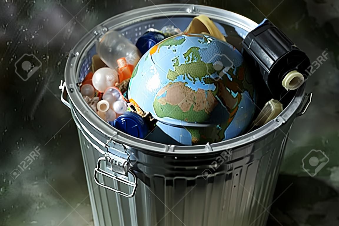 Earth in a trash can with plastics and rubbish