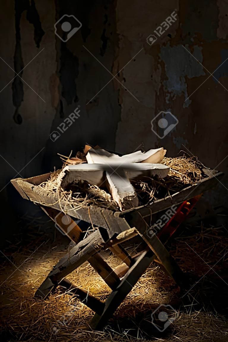 Pusty żłób z krzyżem w cieniu starego brudnego stodole