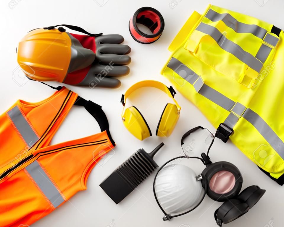 Work safety protection equipment flat lay. Industrial protective gear on white background, top view. Construction site health and safety concept