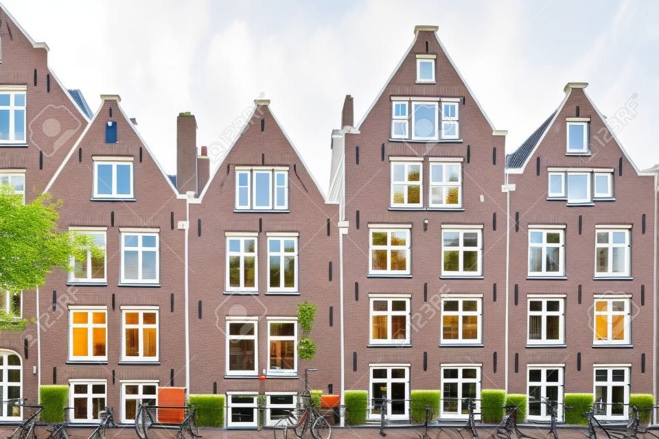 Casas de Amsterdã, fachada de cor branca e janelas, bicicleta estacionada no exterior. Edifício no bairro residencial, Holanda Holanda