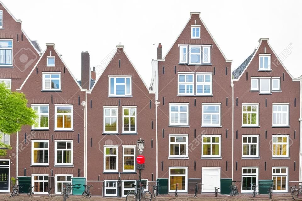 Casas de Amsterdã, fachada de cor branca e janelas, bicicleta estacionada no exterior. Edifício no bairro residencial, Holanda Holanda