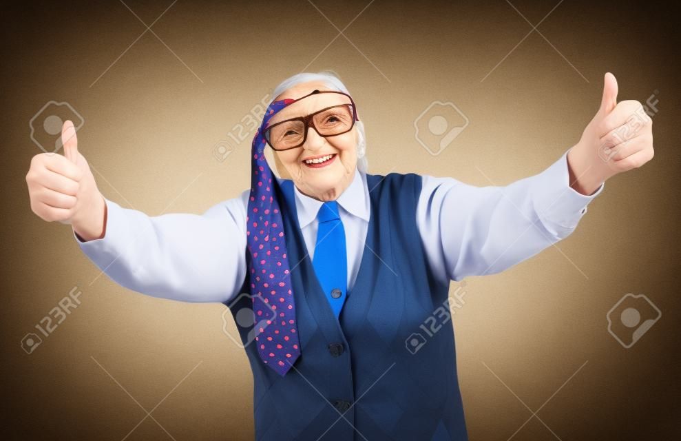 Funny grandma's studio portarit with a tie on her forehead, showing thumbs up