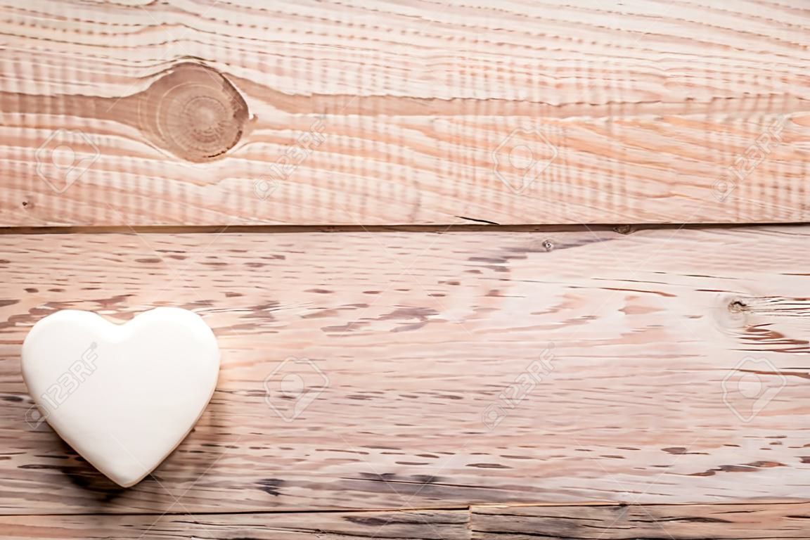 Coeur blanc et fond en bois.