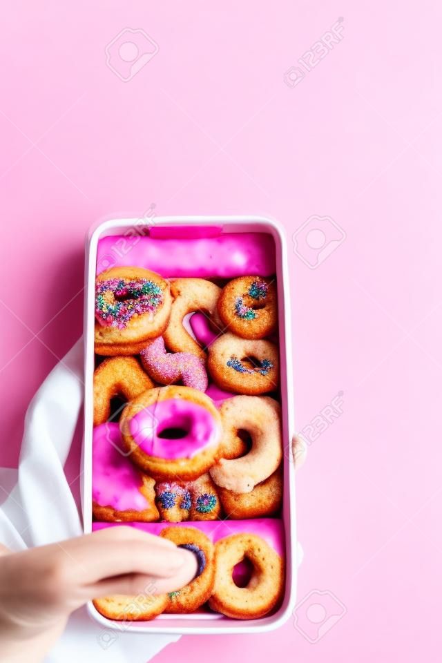 Taking a photo of food - colorful drink and pink glazed donuts on white table, with blurred background, flatlay top view
