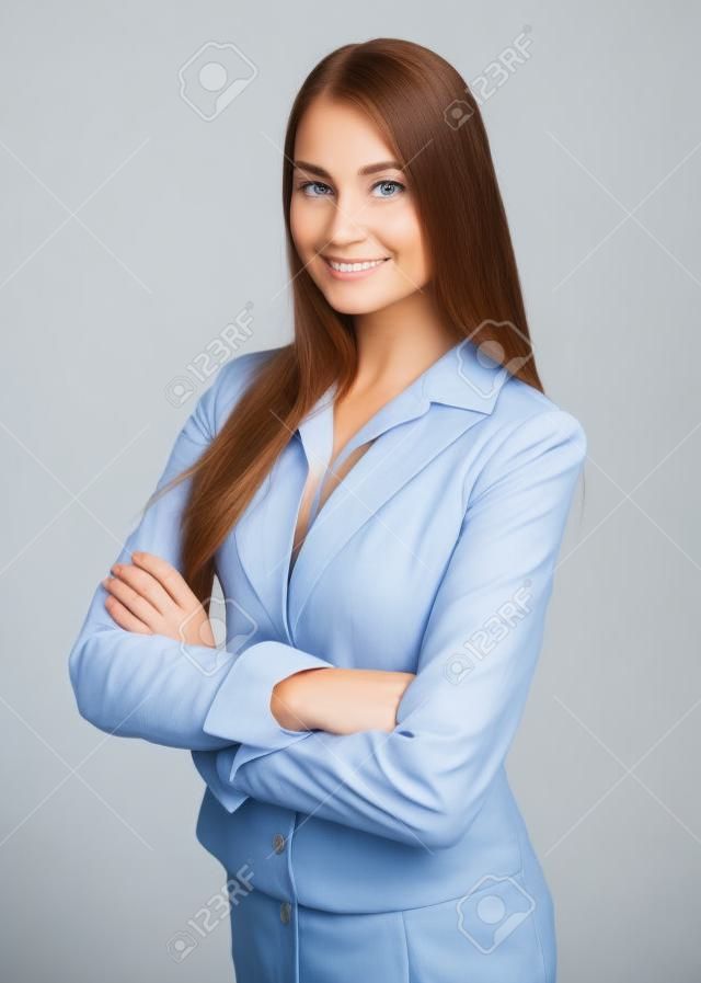 Portrait of young smiling businesswoman standing with hands folded against isolated on white background