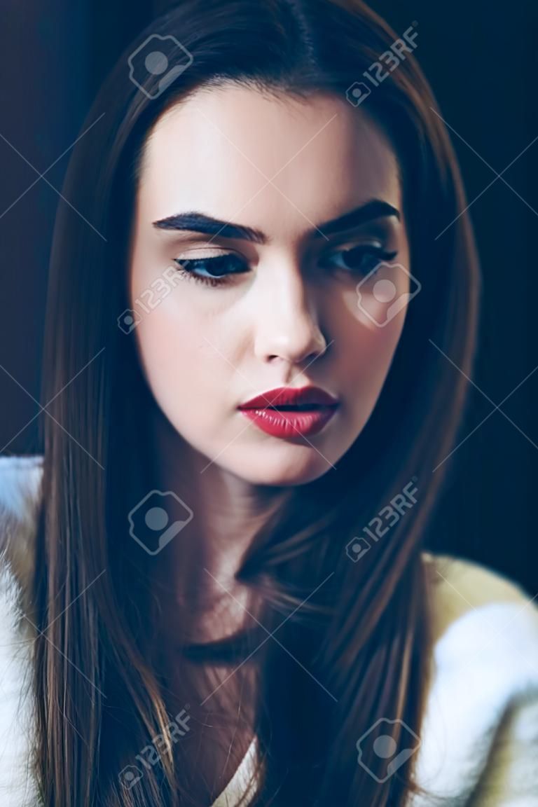 若い美しい女性の肖像画、クローズアップ。赤い口紅とスタイリッシュな髪型のかわいい女の子。女性モデルのペンシブな表情