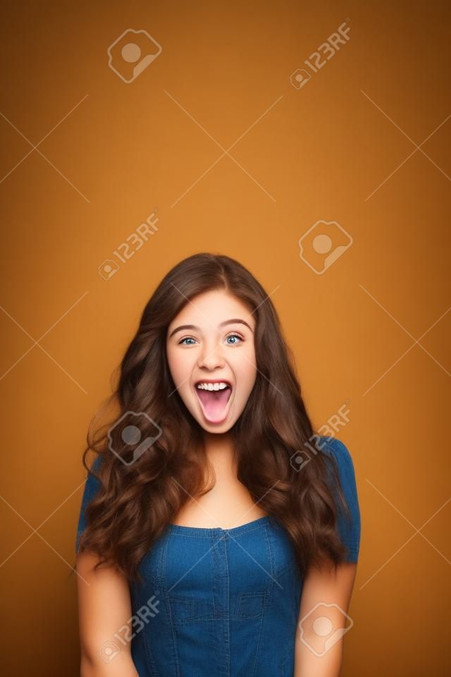 retrato de la atractiva muchacha sorprendida emocionada adolescente sonrisa, la boca abierta