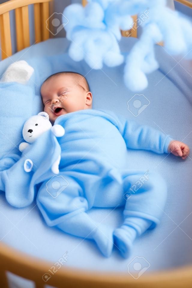 Seven month old baby boy sound asleep in his crib