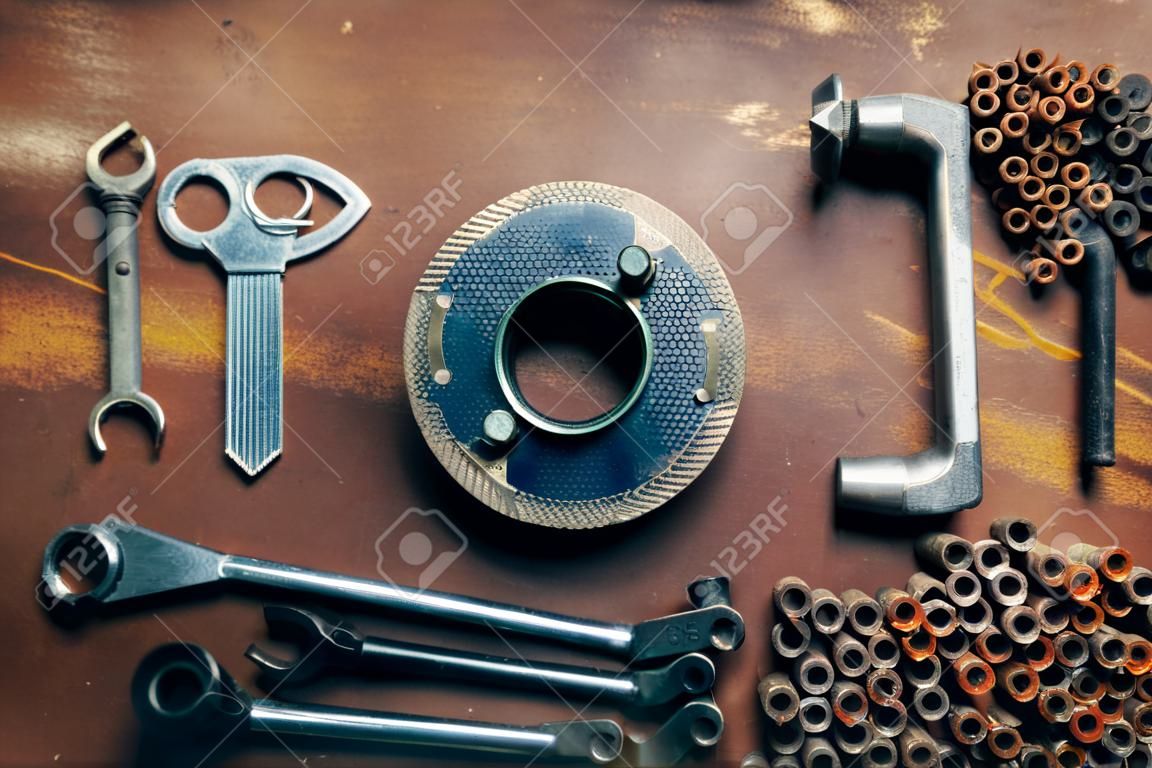 the word Tools made of the different tools lying on a rusty metal background.