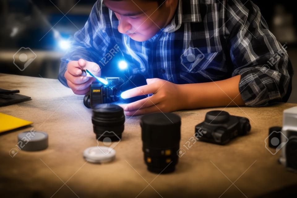 Maintenance of photo camera at workshop. Photographer cleaning photocamera light sensor. Professional photographing equipment care, technology, hobby concept