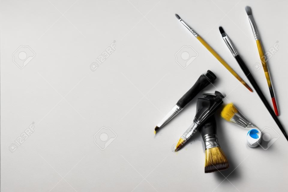 Blank canvas with oil paint and brush flat lay. Professional painter workplace flat lay. Artist's equipment assortment background. Drawing lessons, art school, young painter, creativity, DIY concept