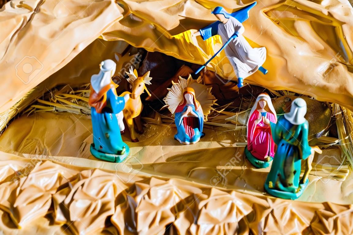 Statue in un presepe di Natale, la Beata Vergine Maria e San Giuseppe guardare il Bambino Gesù Santo in una mangiatoia nella paglia, mentre il bue e l'asino stanno effettuando il riscaldamento dell'aria