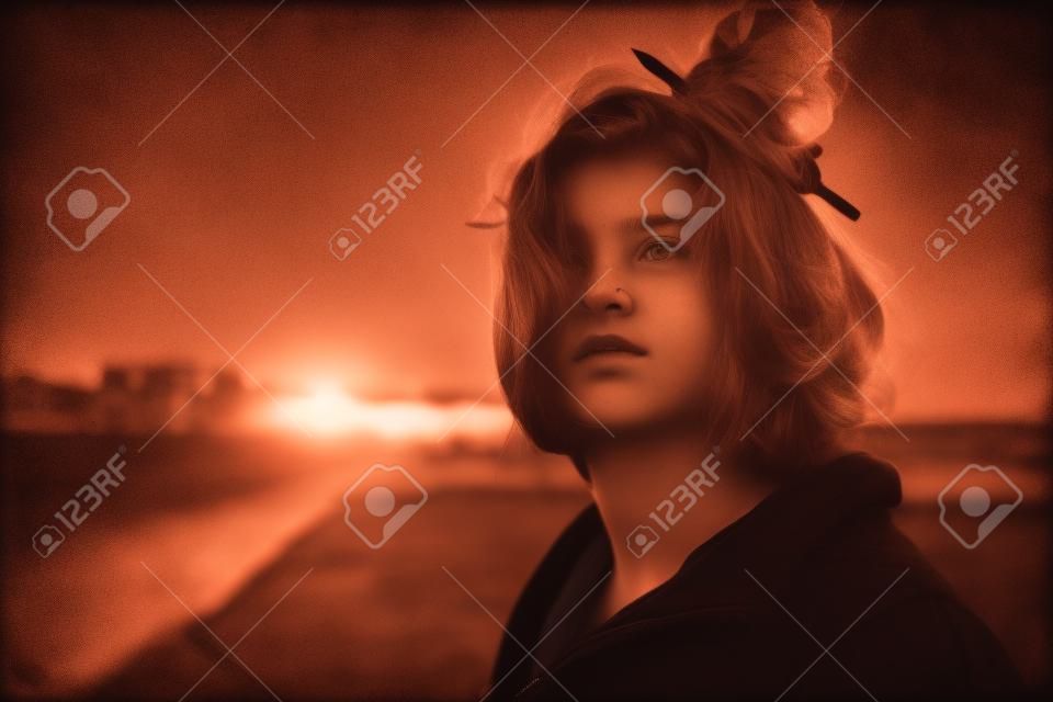 portrait of teenage girl on embankment in sunset, toned photo