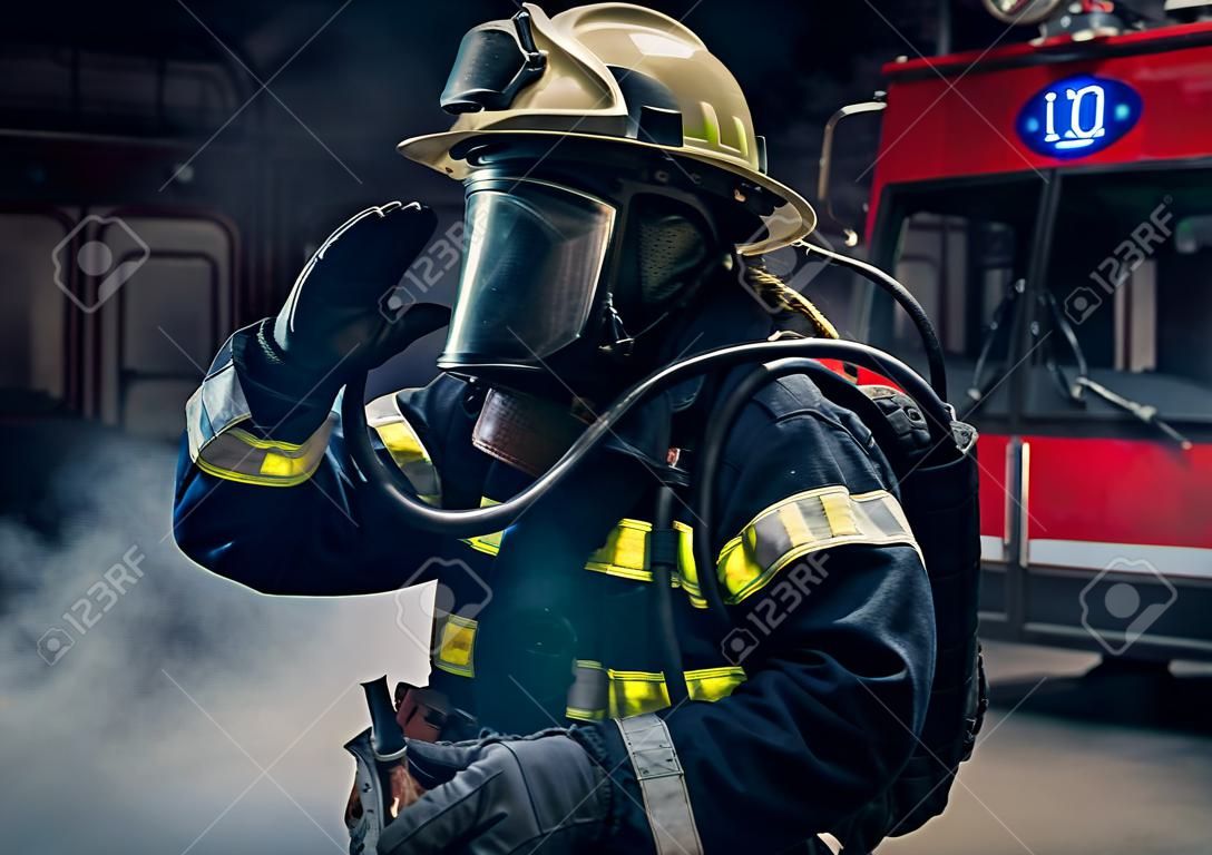 Portrait d'un pompier portant des aiguillages et un casque de pompier. Fond sombre avec fumée et lumière bleue.