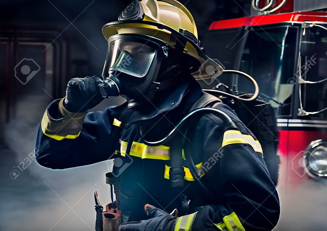 Portrait d'un pompier portant des aiguillages et un casque de pompier. Fond sombre avec fumée et lumière bleue.