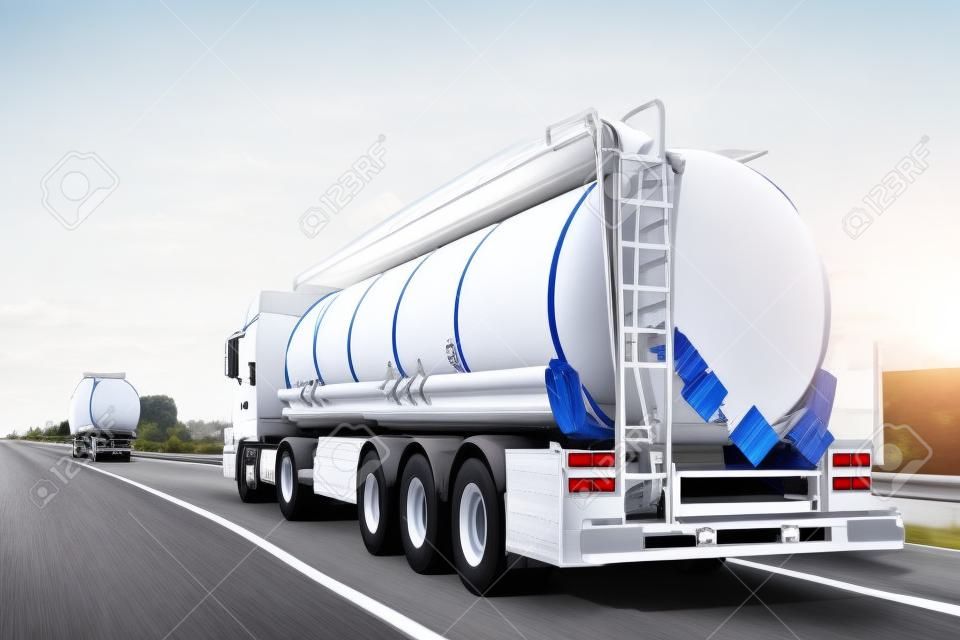 White big modern tanker shipment cargo commercial semi trailer truck moving fast on motorway road city urban suburb. Business distribution logistics service. Lorry driving highway sunny day