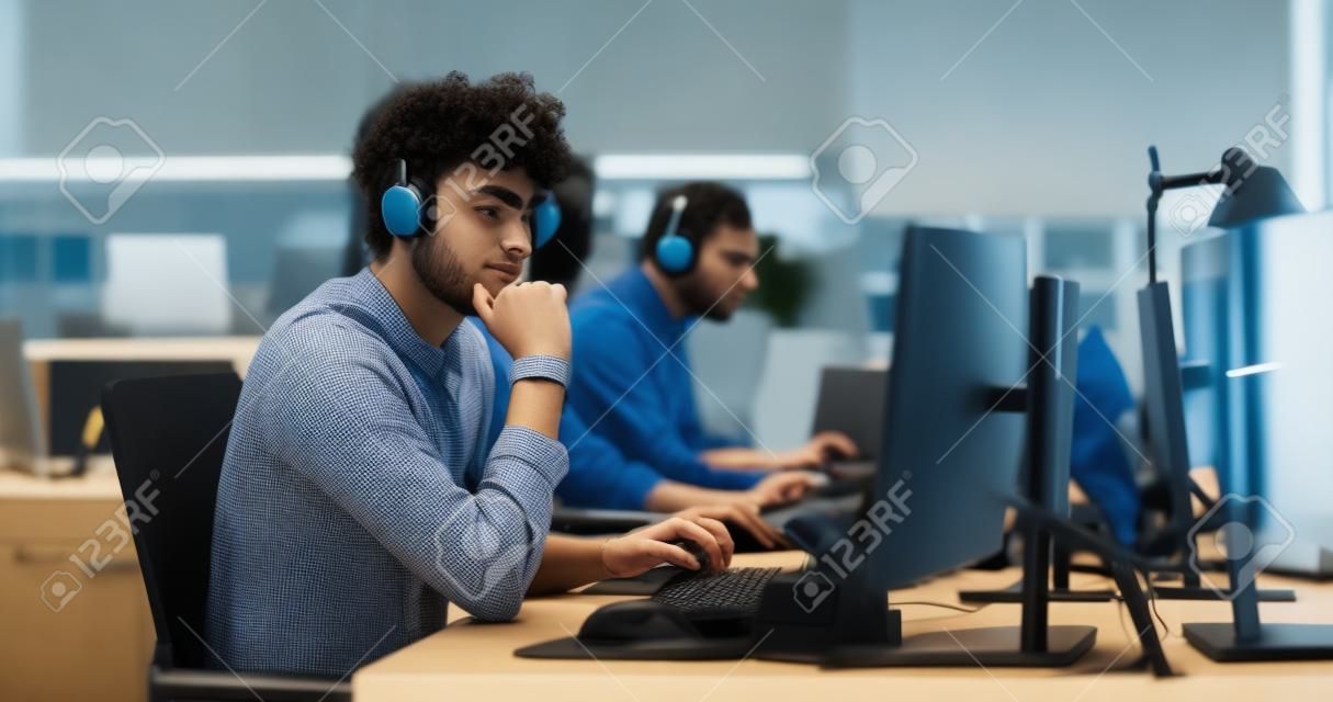Ritratto di un giovane ingegnere premuroso che lavora al computer in un ambiente di ufficio tecnologico. giovane donna che indossa le cuffie, scrivendo codice software per un
