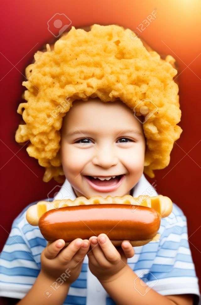 Kleines Kind isst Hot Dog, Kid hält Hot Dog.
