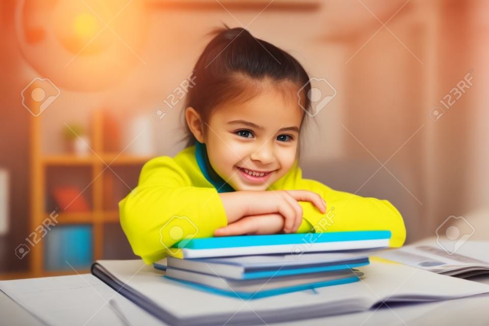 Lächelndes Mädchen, das zu Hause studiert