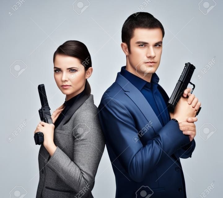 par de buenos guardaespaldas del hombre y la mujer con armas de fuego en manos aislado en un fondo blanco