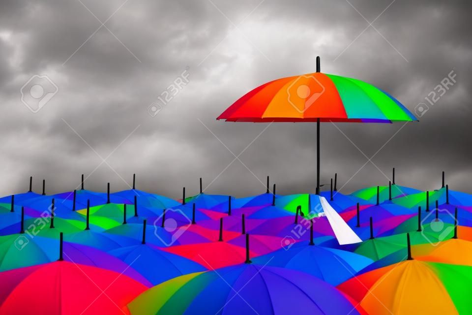 regenboog paraplu in massa van zwarte paraplu's
