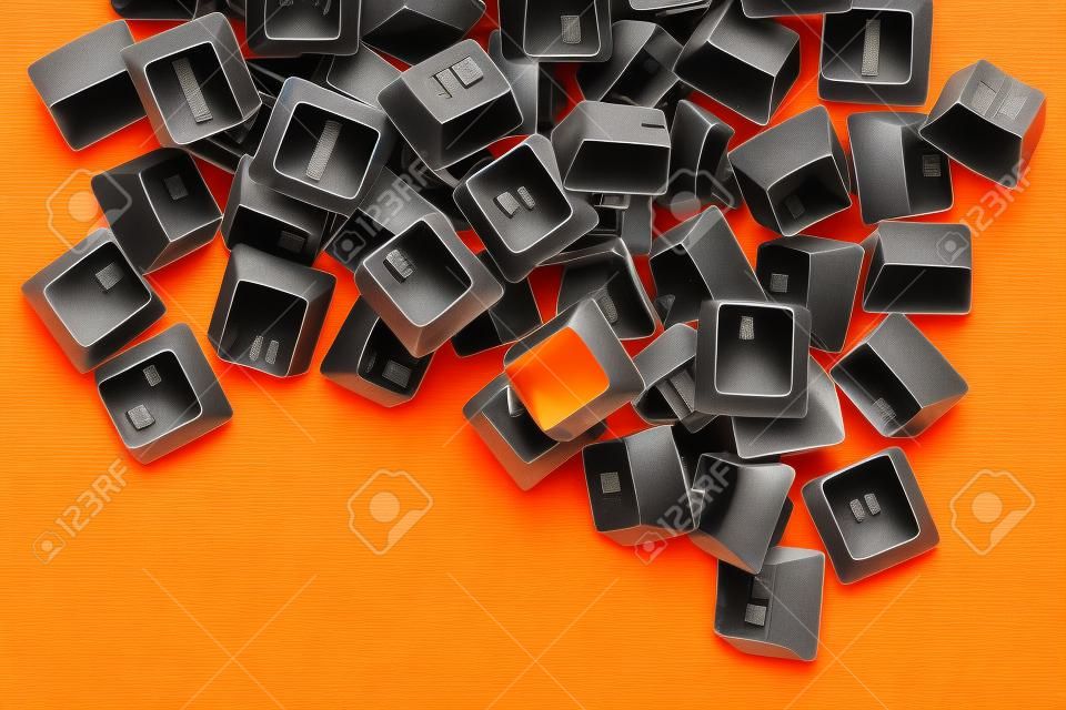 Stapel oude computertoetsenbordtoetsen op de oranje achtergrond. computerreparatie, service. kopieerruimte.