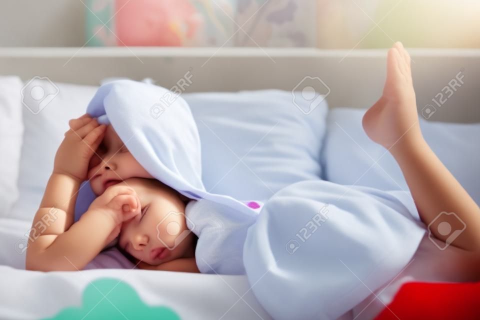 Young little girl lying in bed at home