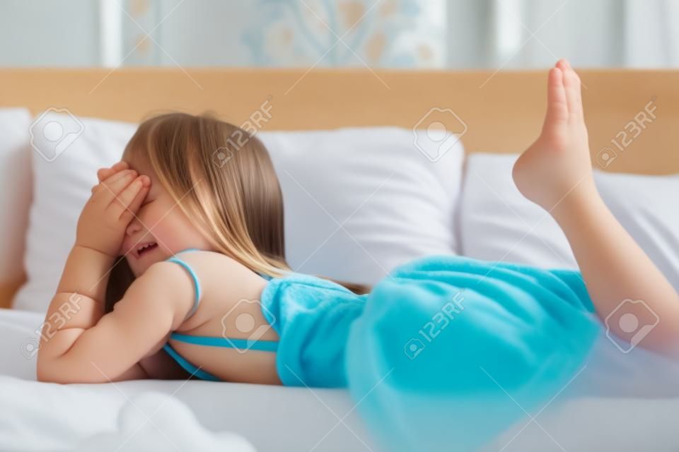 Jeune petite fille couchée dans le lit à la maison