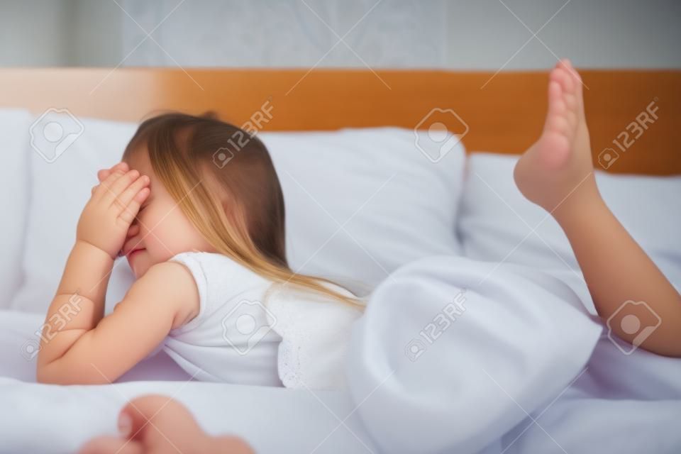 Junges kleines Mädchen zu Hause im Bett liegend