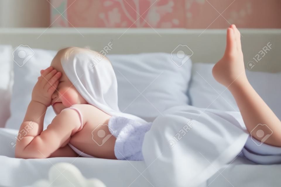 Jeune petite fille couchée dans le lit à la maison
