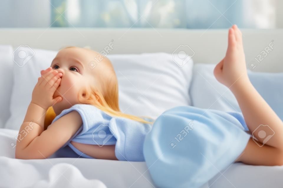 Young little girl lying in bed at home