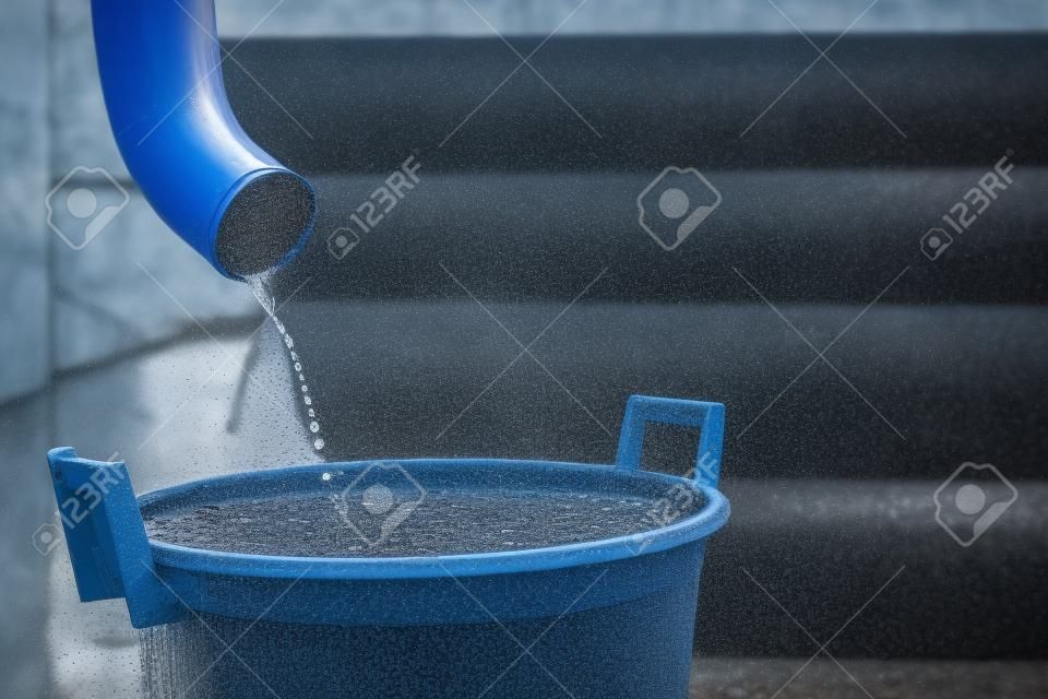 Tiro de água da chuva de uma sarjeta em um reservatório de coleta de água