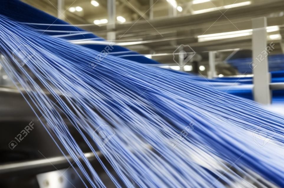 Textilindustrie - Garnspulen auf Spinnmaschine in einer Textilfabrik