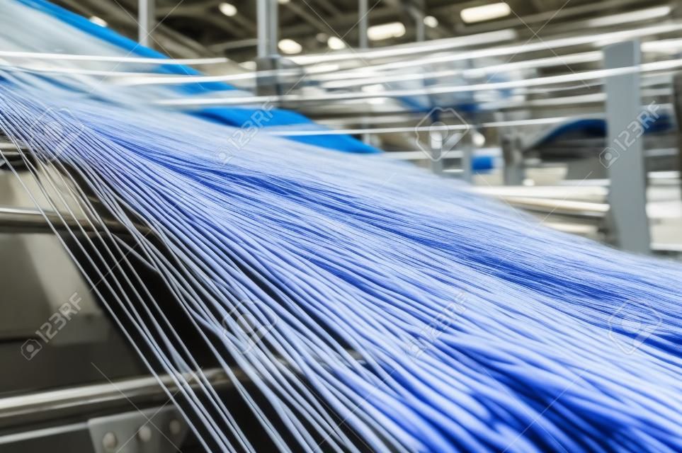 Textilindustrie - Garnspulen auf Spinnmaschine in einer Textilfabrik