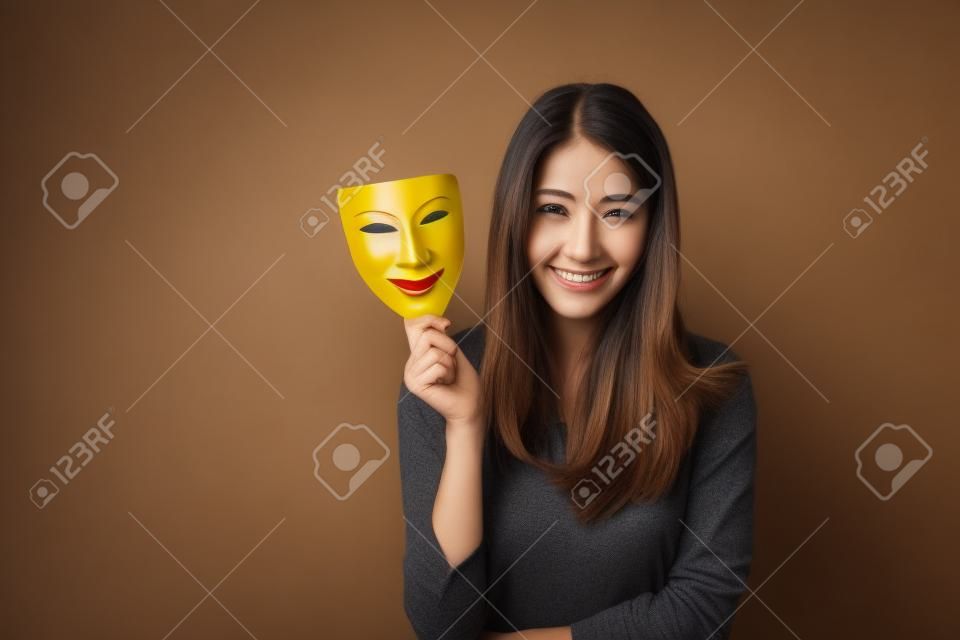 Mulher segurando máscara de seu rosto feliz