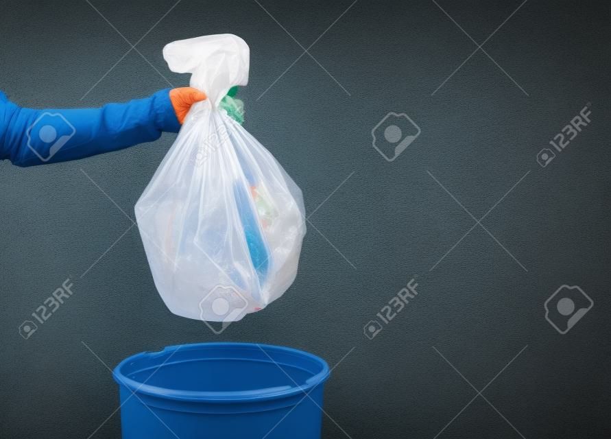 Person throwing out garbage in plastic bag