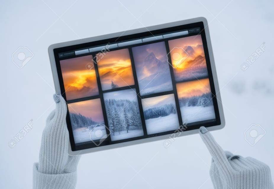 Vrouw met behulp van tablet en bladeren prachtige winter fotografie online
