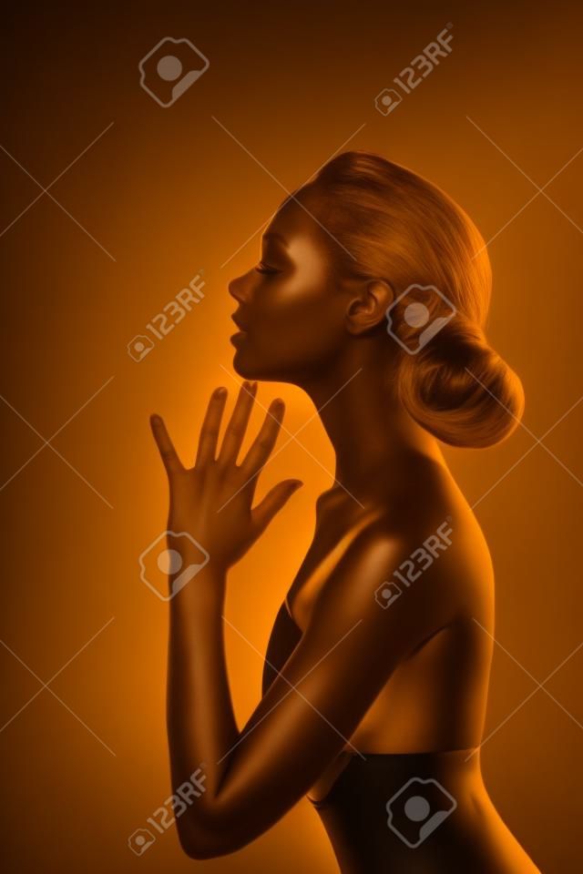 Woman with Golden Body over Black Background