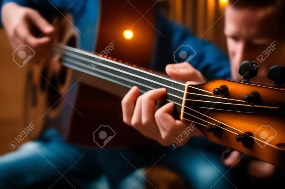 Hombre tocando guitarra acústica, cubierta para cursos en línea, aprendiendo en casa.