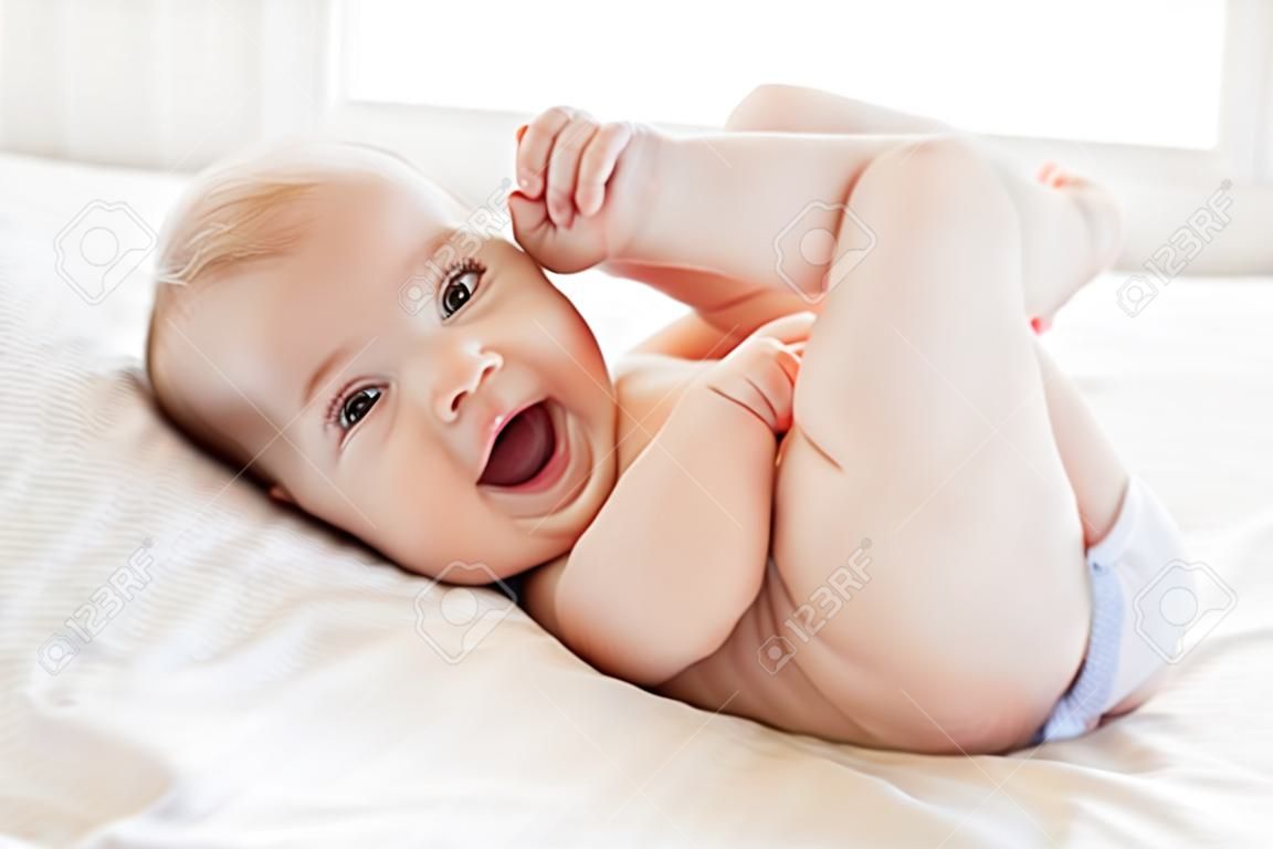 건조하고 행복한 느낌. 침대에 누워있는 동안 웃는 행복 한 작은 아기
