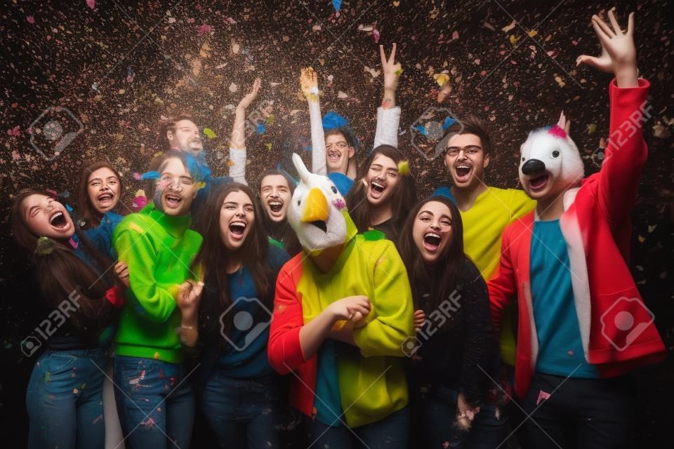 Ceci est mon année! Groupe de jeunes dans des masques d'animaux jetant des confettis et l'air heureux