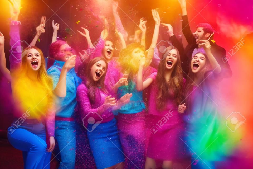 diversión del partido. Grupo de jóvenes hermosas que lanzan confeti de colores y mirando feliz