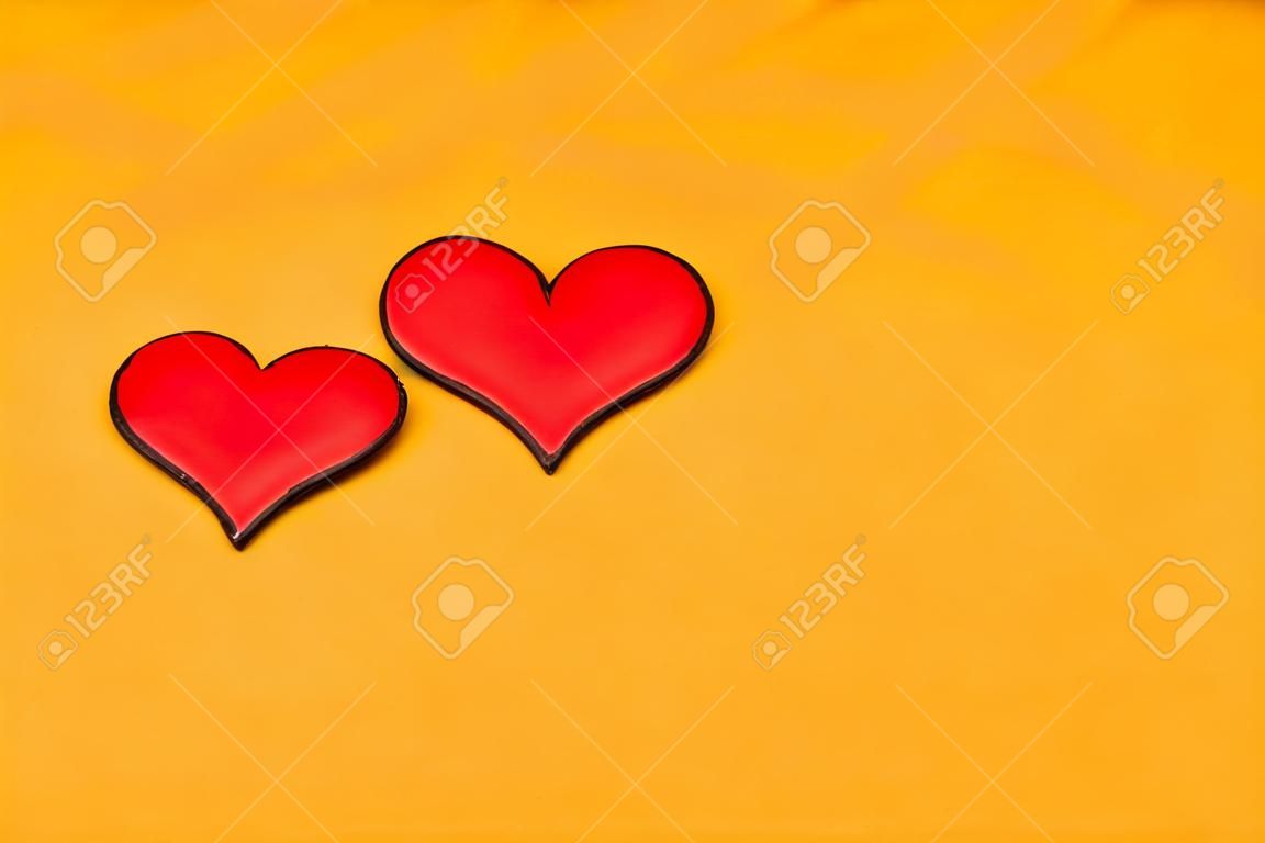 Two red hearts on a yellow background with copy space. Postcard for congratulations. Place for text. Valentine's Day.