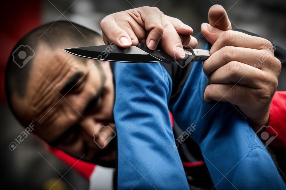 L'instructeur de Kapap démontre l'attaque de couteau d'auto-défense d'arts martiaux désarmant la technique contre la menace et l'attaque de couteau. Rétention d'arme et désarmement. Démonstration avec un vrai couteau en métal