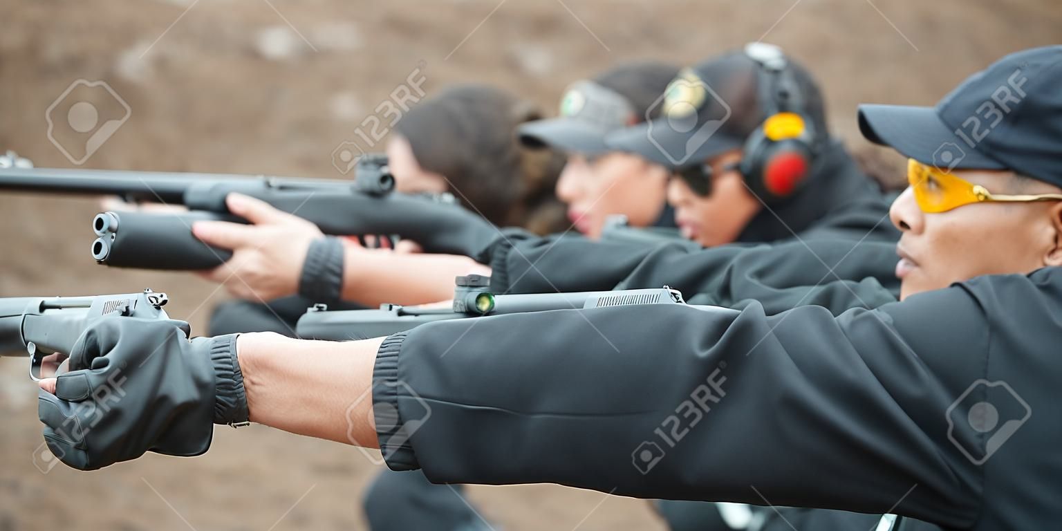 Groupe de tir au pistolet d'entraînement civil sur cible sur un champ de tir extérieur. Entraînement aux armes de l'équipe civile